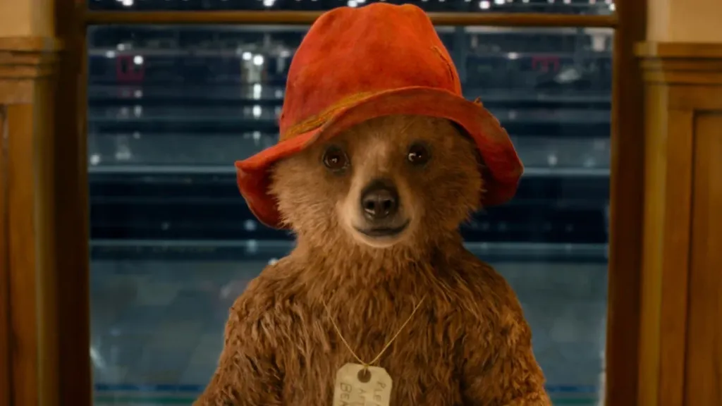 Paddington Bear stands in a doorway in 