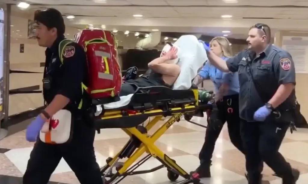 Four EMTs transport a patient on a stretcher.