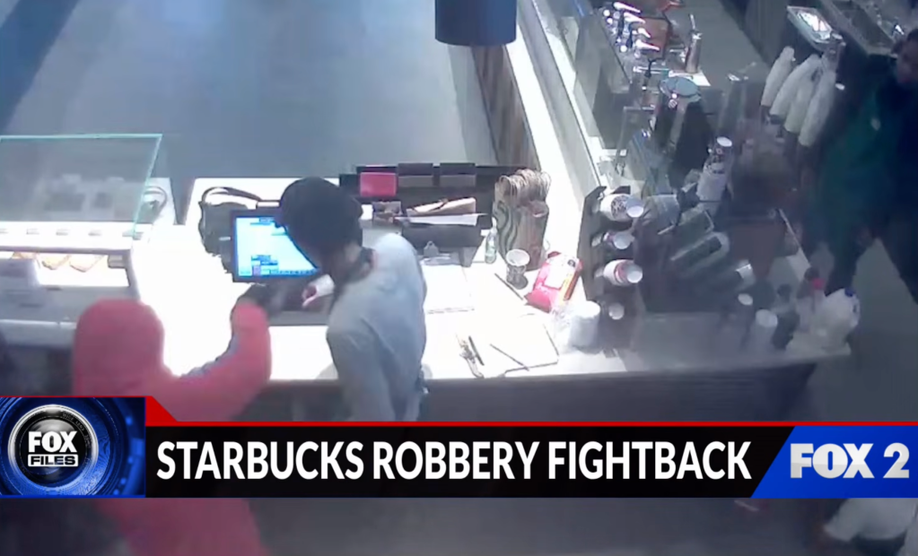 Security footage showing two men, one in a pink hoodie and the other in a black beanie, behind the counter of a Starbucks.