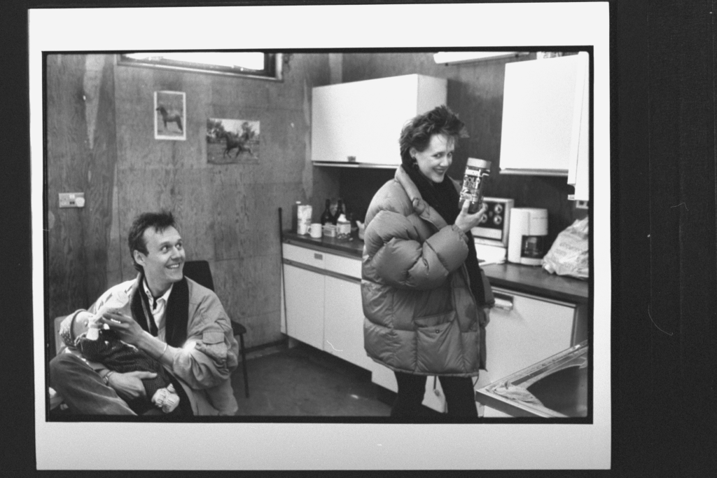 Anthony Head bottle-feeding daughter Daisy as Sarah Fisher holds up a jar of Gold Blend coffee.