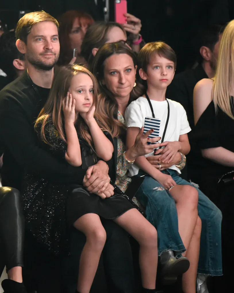Tobey Maguire, Ruby Maguire, and Otis Tobias Maguire with Jennifer Meyer in the middle, sitting at the Saint Laurent at the Palladium show.