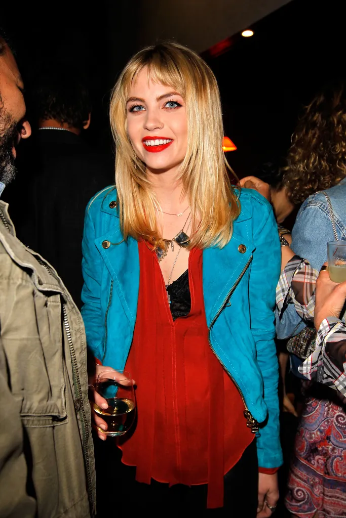 Actress Daveigh Chase smiling while holding a glass of wine.