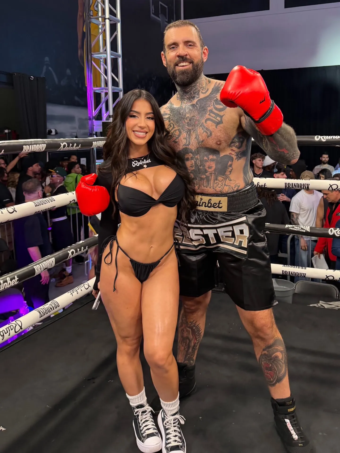 Adam22 and Lena the Plug standing in a boxing ring.