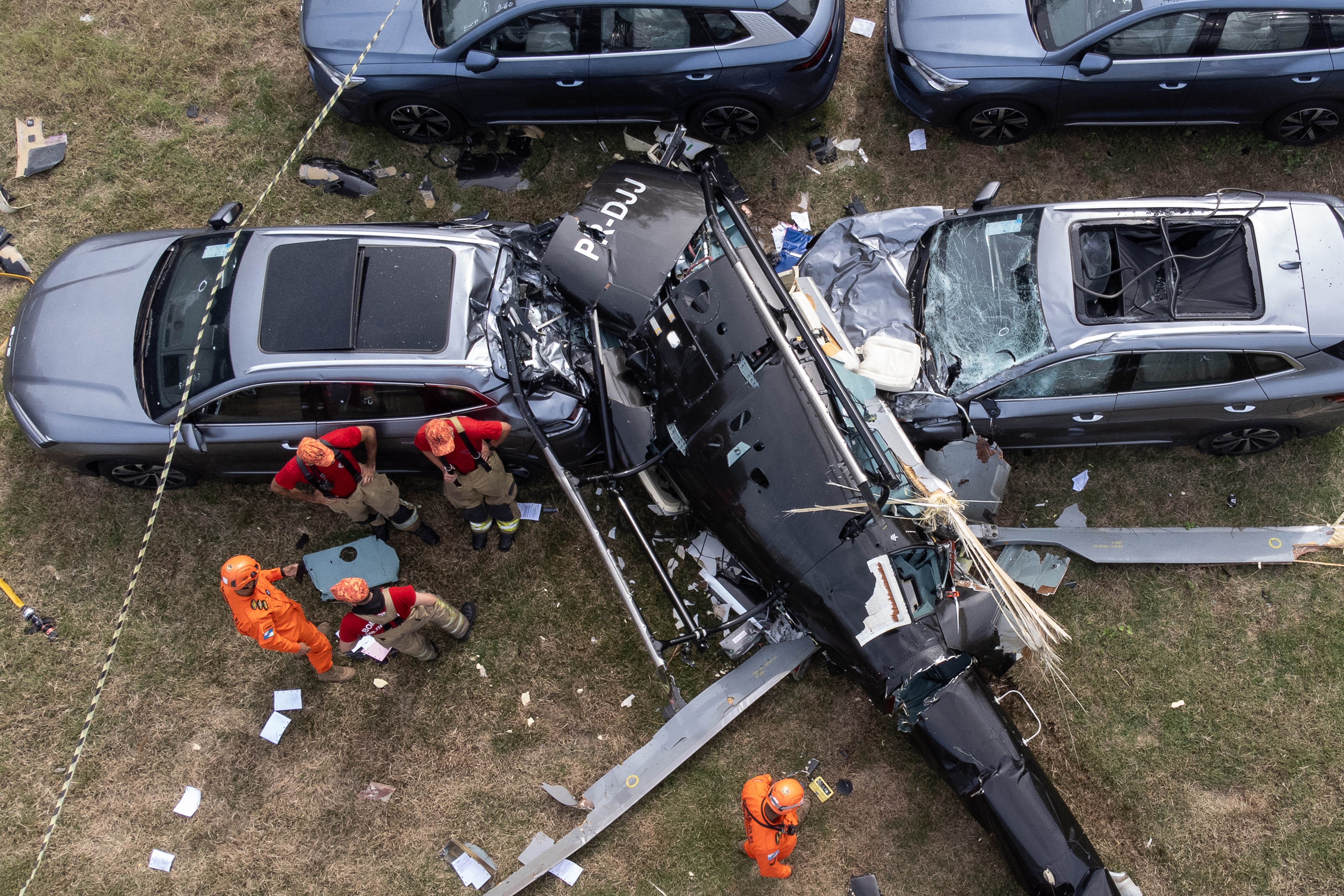 Aerial view of firefighters examining the wreckage of a helicopter and damaged cars after a crash in Rio de Janeiro, Brazil.