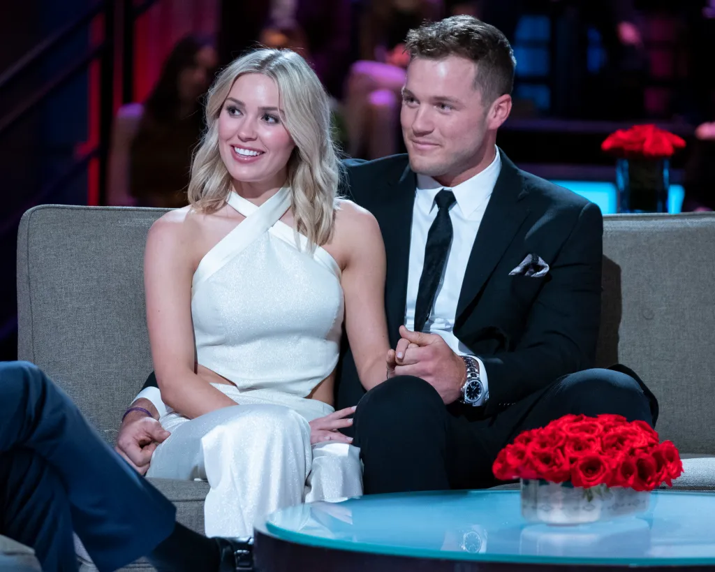 Cassie and Colton Underwood sitting on a couch.
