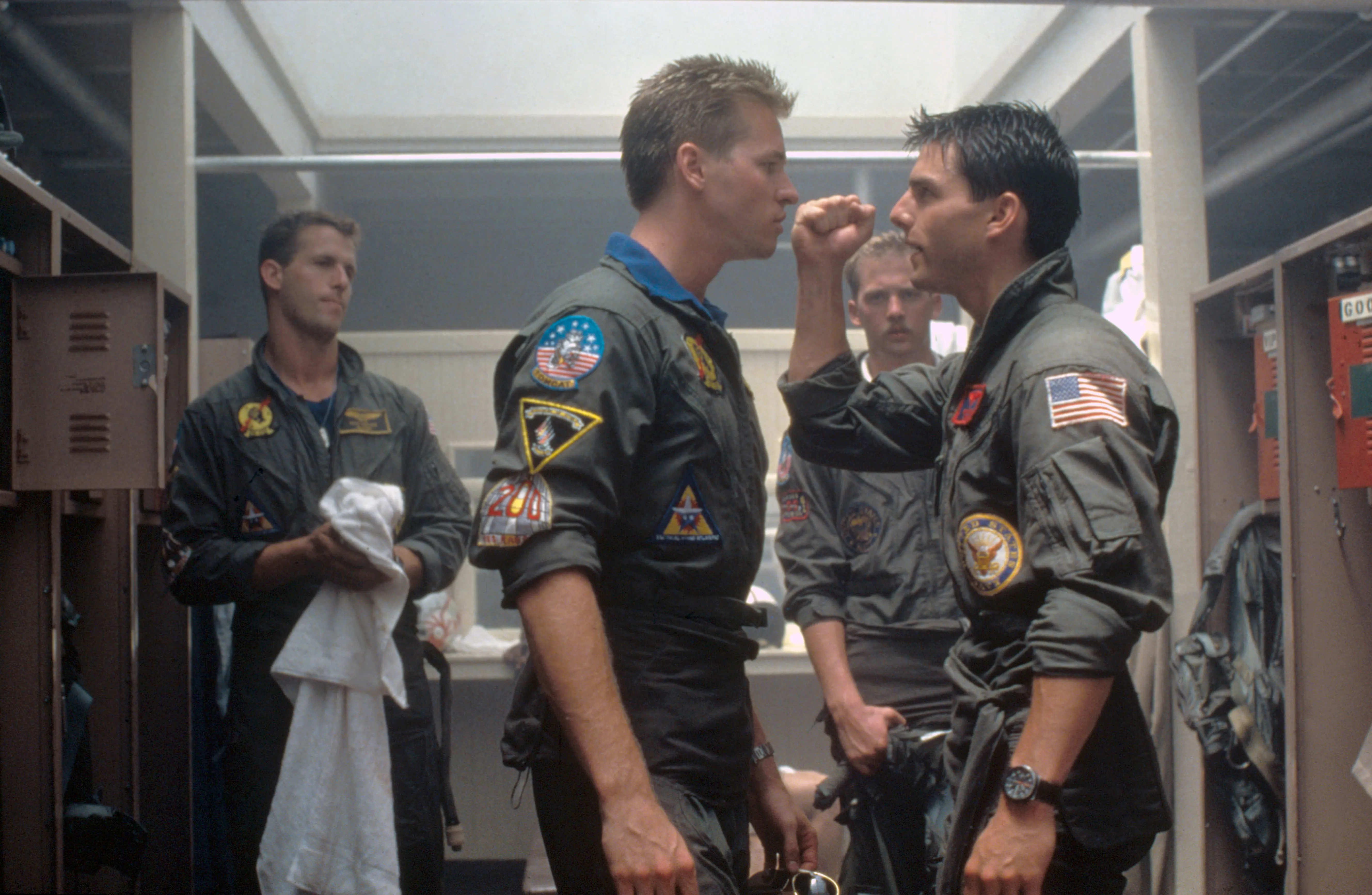 Val Kilmer and Tom Cruise confronting each other in a movie set scene from Top Gun.