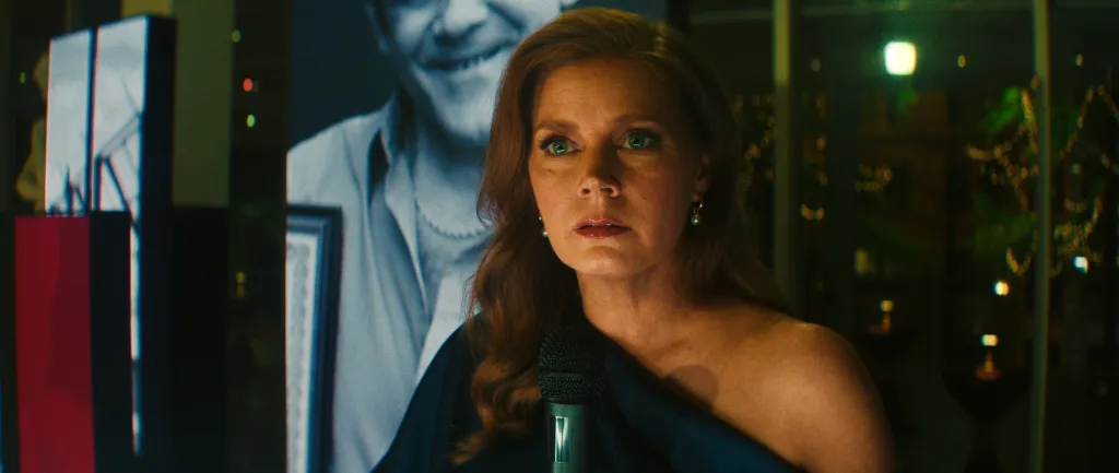 Amy Adams as Cami in "Cape Fear" with a black-and-white image of a man in the background.