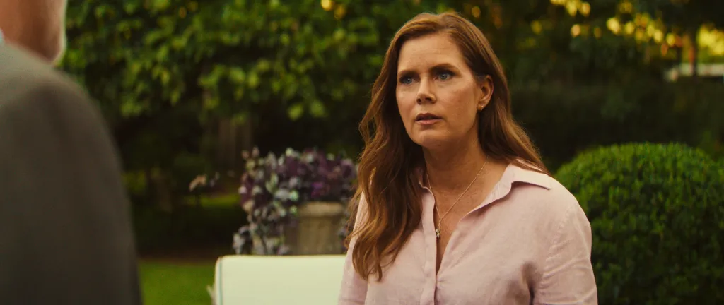 Amy Adams with long wavy red hair wearing a light pink shirt and silver necklace.