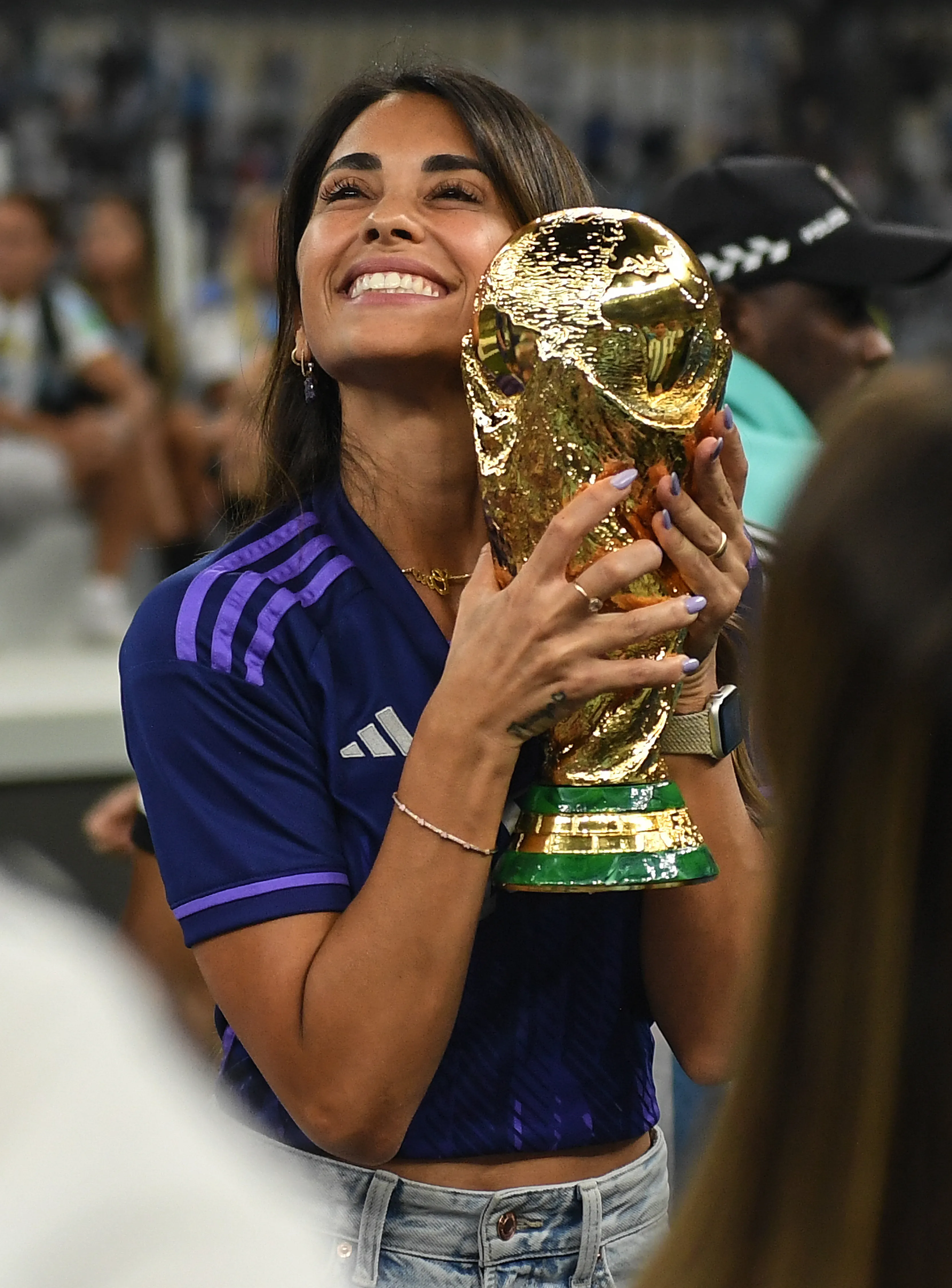 Antonela Roccuzzo holding the FIFA World Cup trophy.