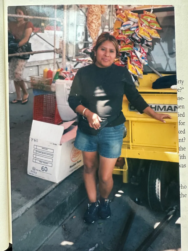 Arabelia Martinez standing next to a street vending cart laden with snacks.