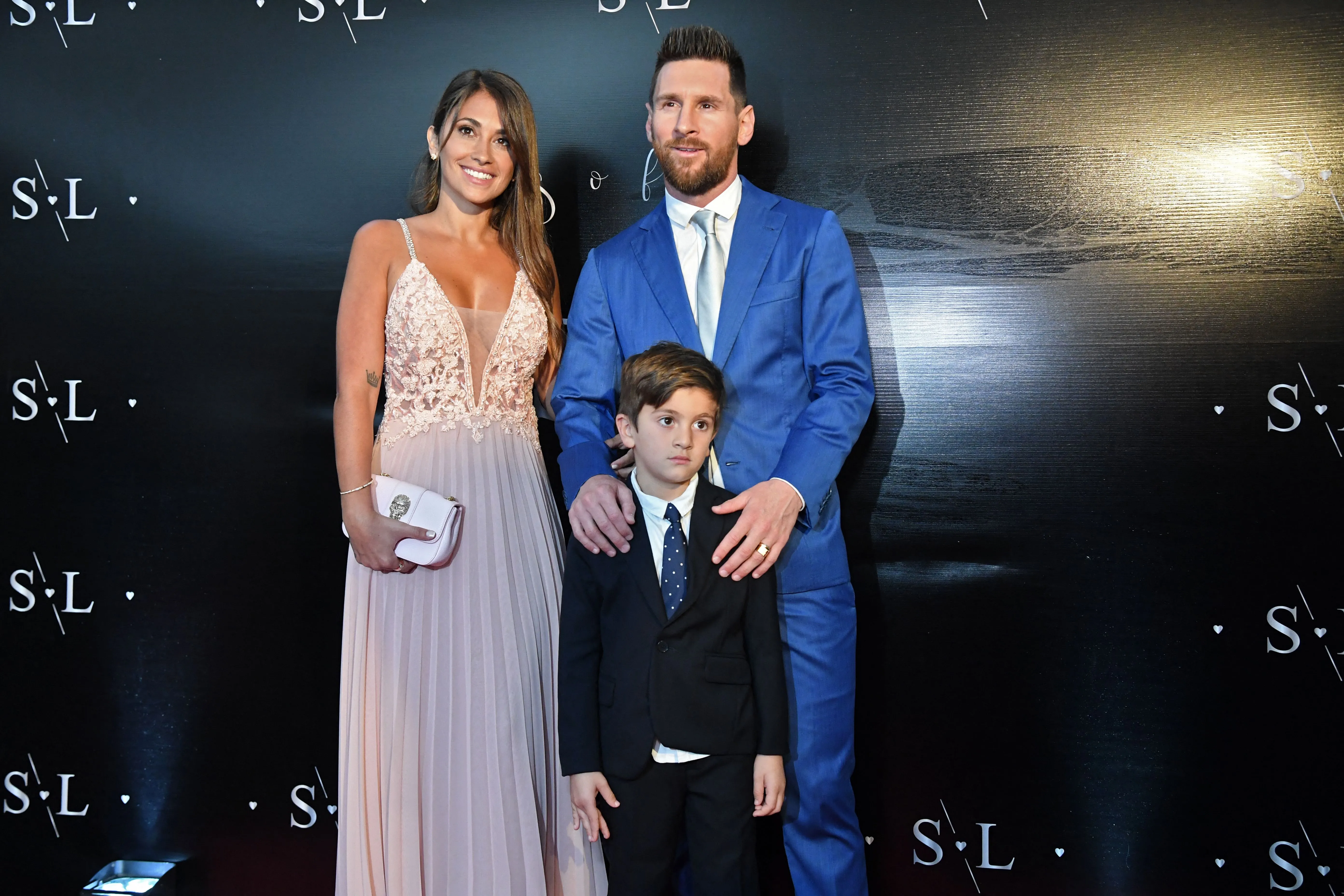 Lionel Messi, his wife Antonella Roccuzzo, and their son Thiago pose for a photo.