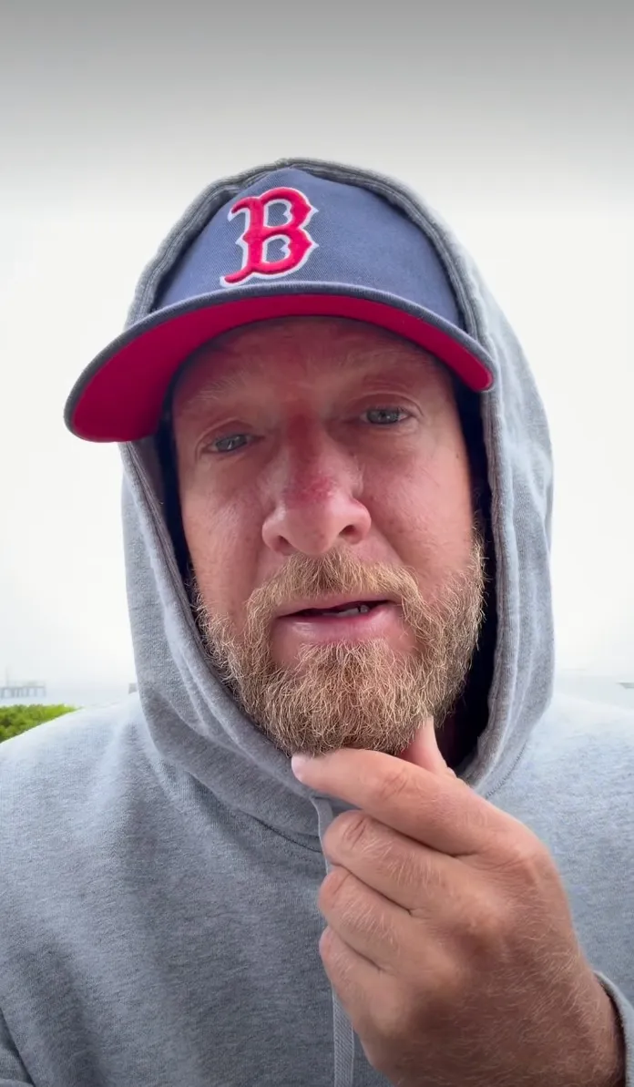Dave Portnoy in a grey hoodie and baseball cap.