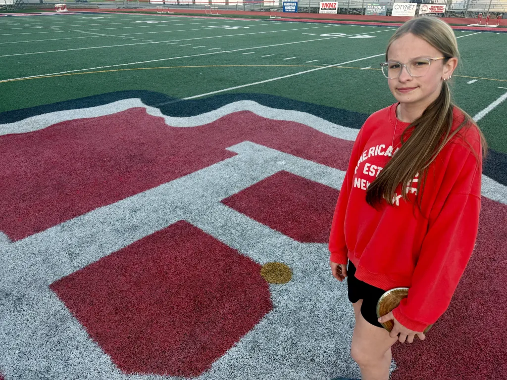 Becky Pepper-Jackson poses on an athletic field with a discus.