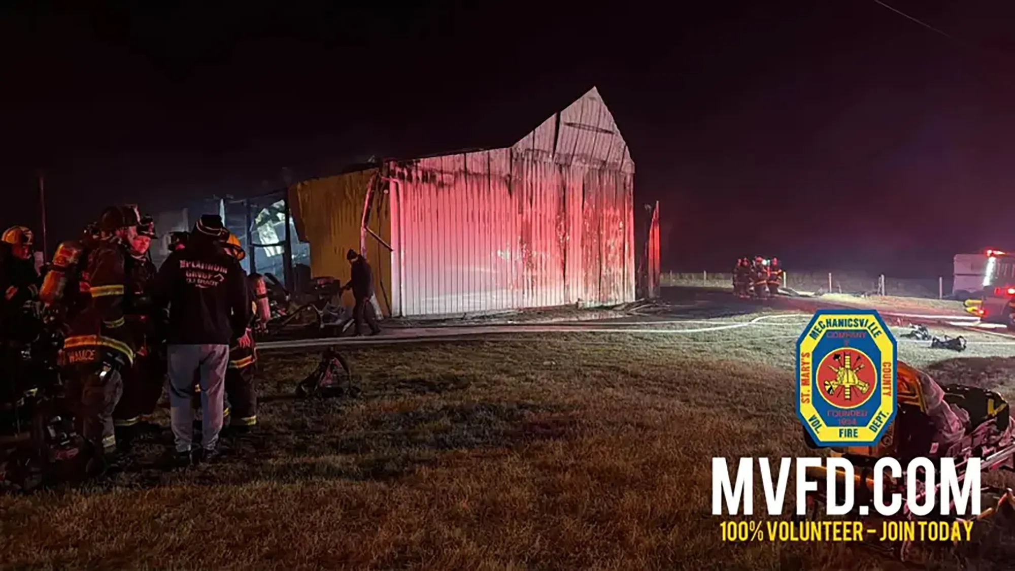 Firefighters working at night to extinguish a barn fire.