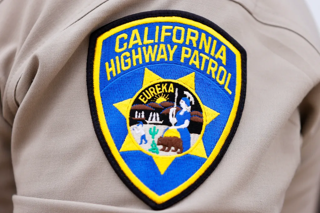 A California Highway Patrol patch, embroidered in blue and gold, on a tan uniform sleeve.