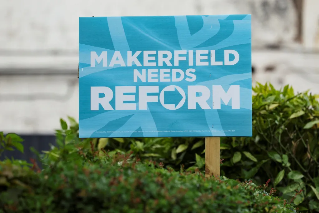 A Reform UK campaign placard in a garden reads "MAKERFIELD NEEDS REFORM."