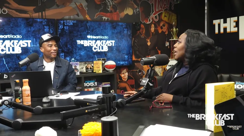 Charlamagne tha God and another person are at microphones in a radio studio.