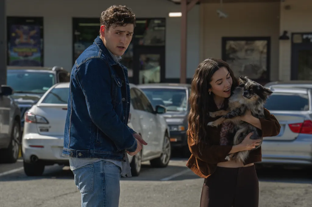 Charlie Hall looks over his shoulder as Kiarra Hamagami Goldberg holds a dog.