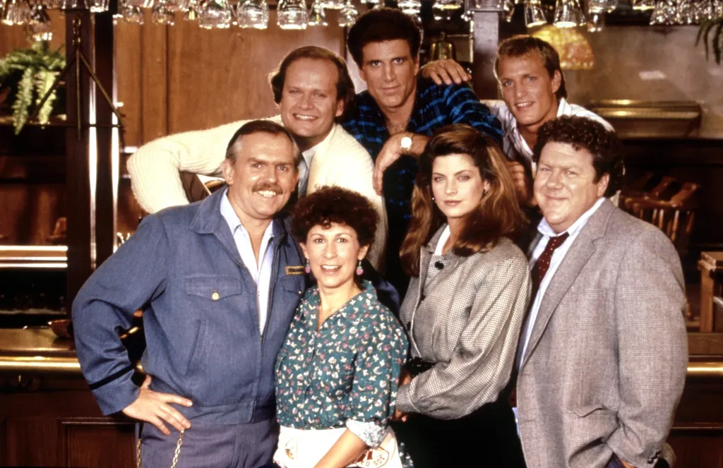 Cast photo of the TV series "Cheers" featuring Ted Danson, Kirstie Alley, Woody Harrelson, George Wendt, Kelsey Grammer, Rhea Perlman, and John Ratzenberger.