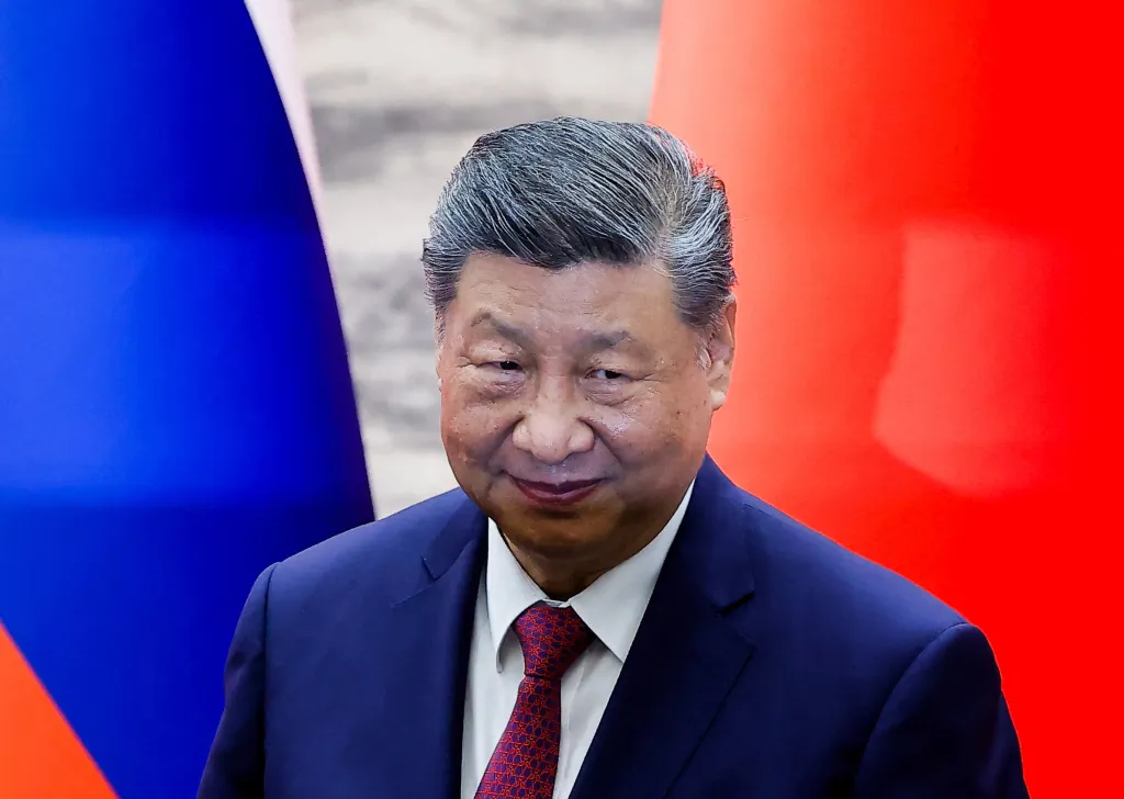 Chinese President Xi Jinping looks on.