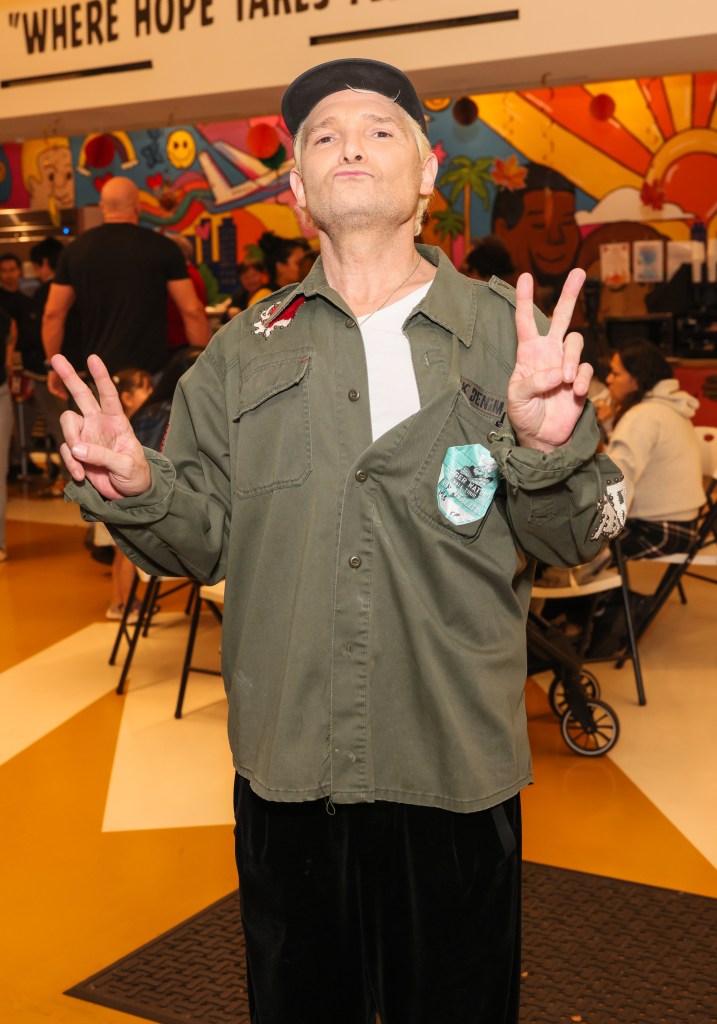 Corey Feldman making peace signs at Hope The Mission's Thanksgiving Dinner.