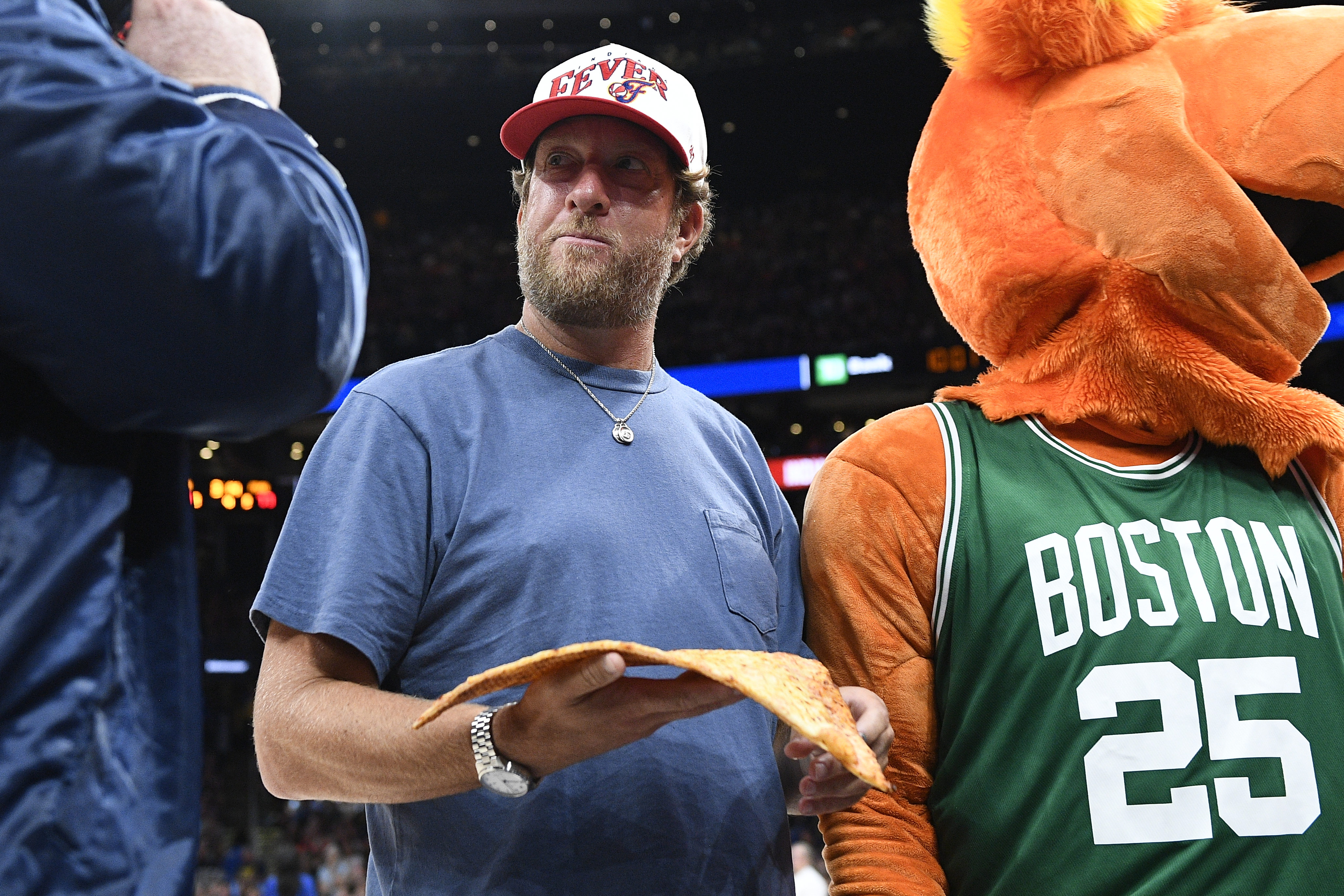 Dave Portnoy holds a slice of pizza.