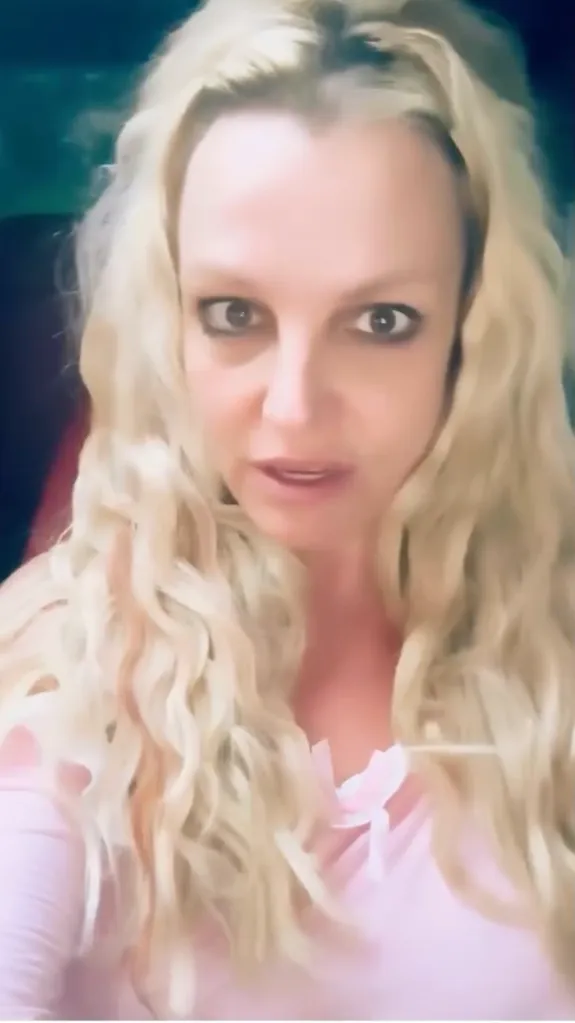 Britney Spears with long, wavy blonde hair looking directly at the camera with a slight frown.