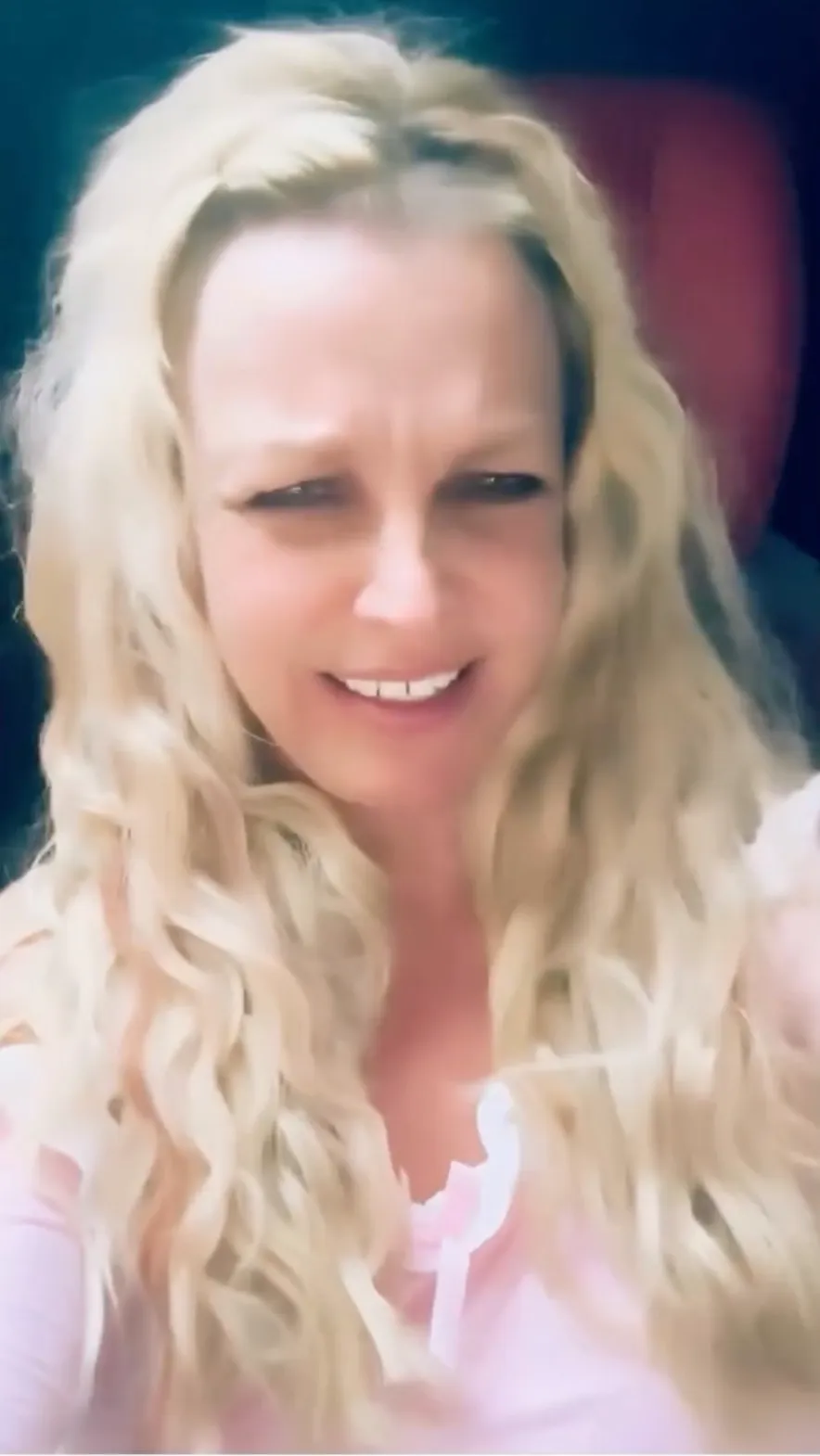 Britney Spears with a confused expression, raising her eyebrows and slightly smiling.