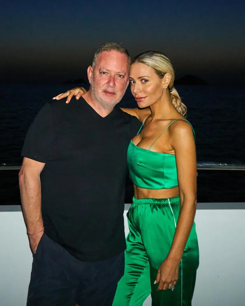 Dorit Kemsley and PK Kemsley pose for a photo at night, with Dorit wearing a green satin outfit.