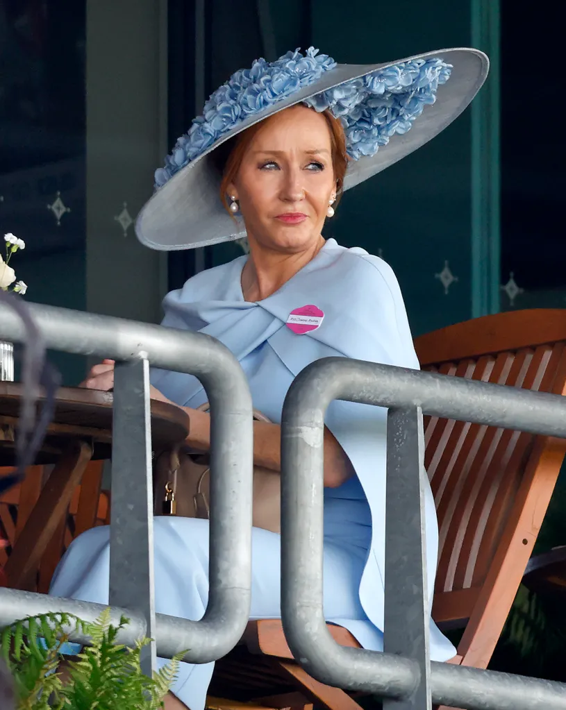 J.K. Rowling in a light blue dress and wide-brimmed hat adorned with blue flowers.