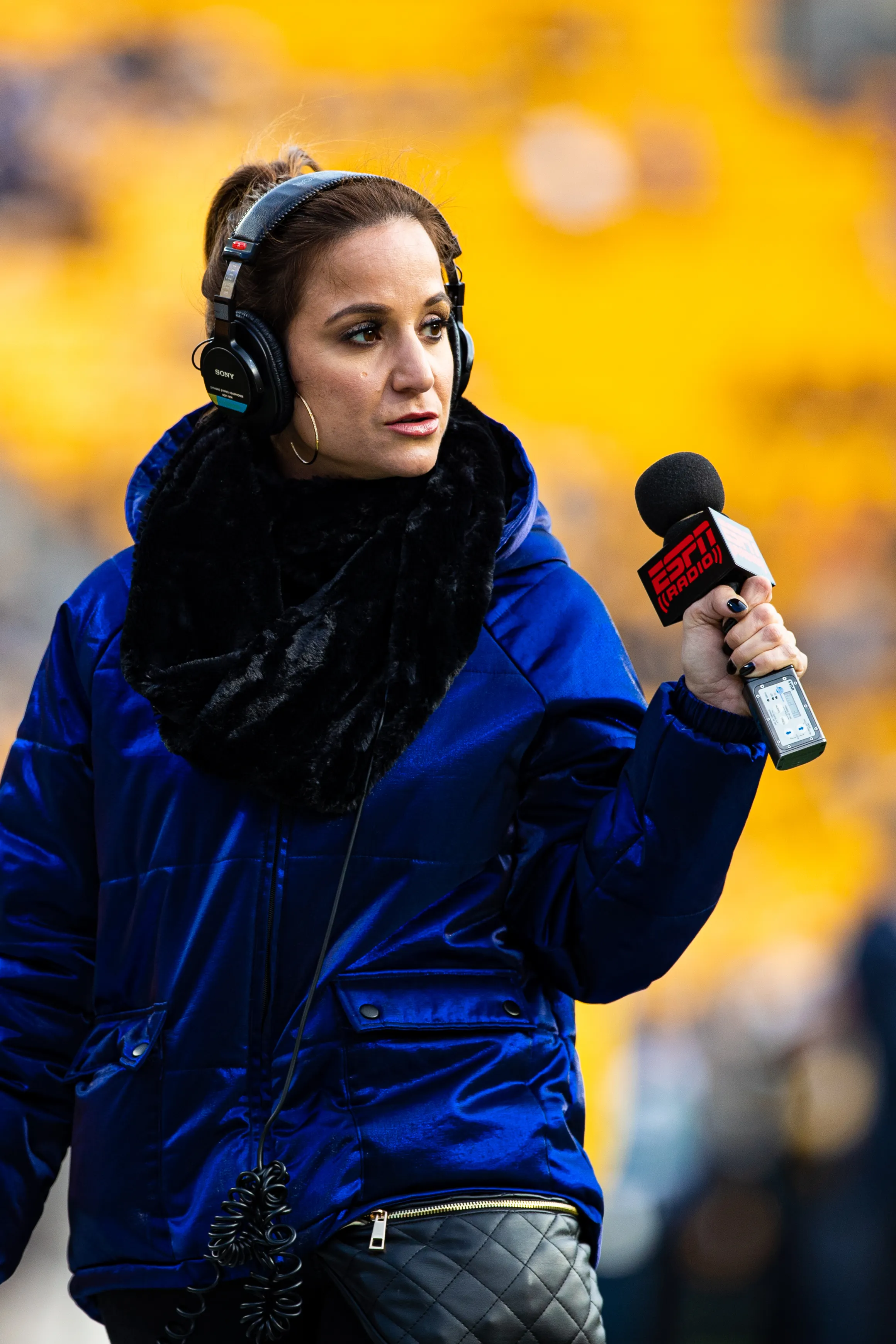 ESPN sideline reporter Dianna Russini wearing headphones and holding an ESPN Radio microphone.