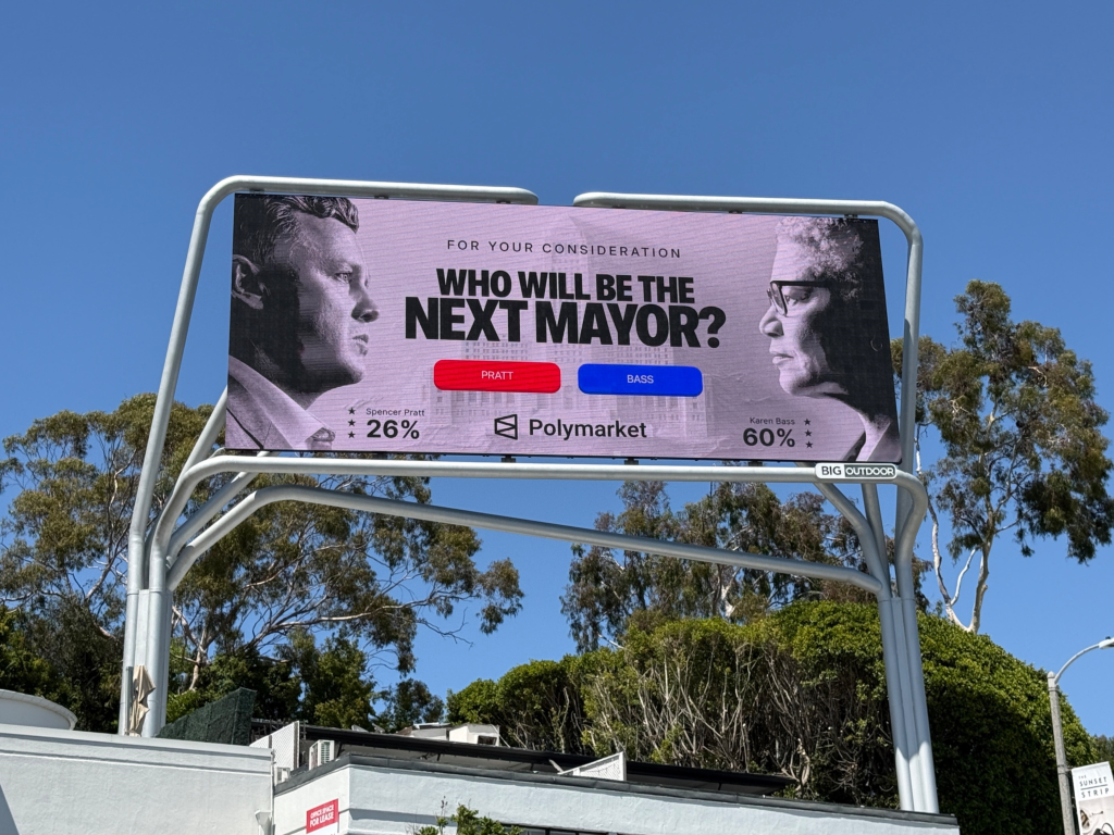 A digital billboard showing Spencer Pratt and Karen Bass with their Polymarket odds for "Who will be the next mayor?".