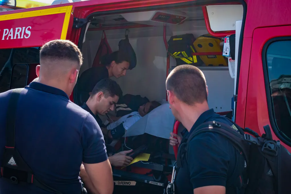 Paramedics treating a person inside an ambulance in Paris during a heatwave.
