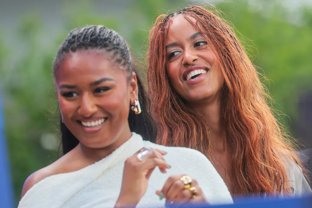 Malia and Sasha Obama smiling at the dedication ceremony for the Obama Presidential Center.