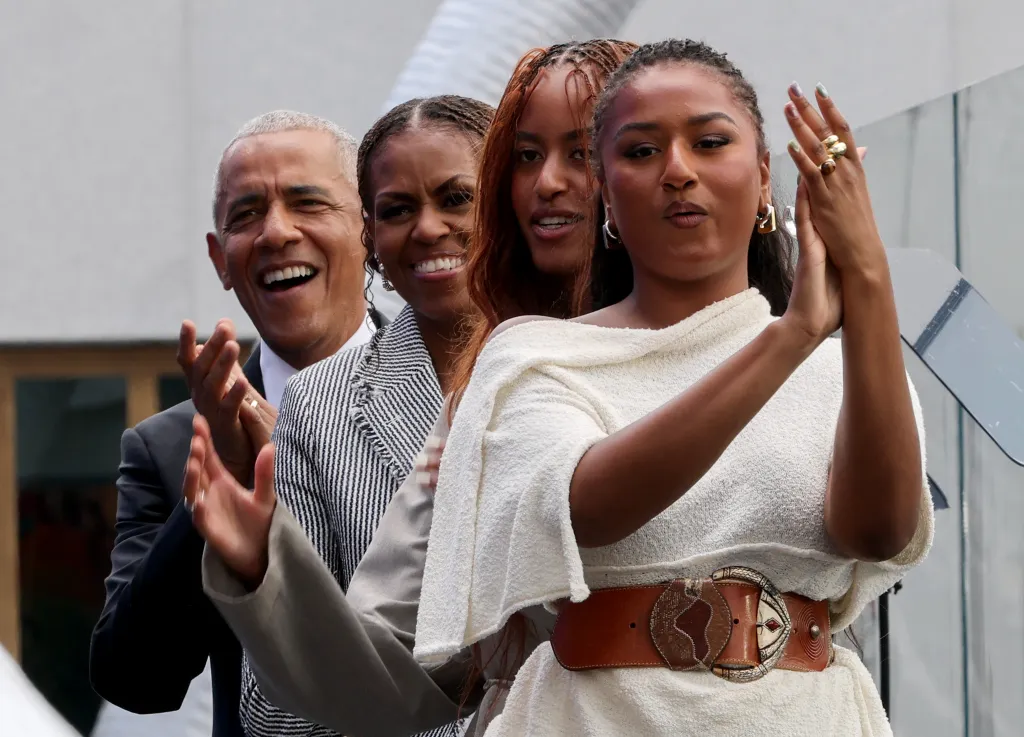 Barack Obama, Michelle Obama, Malia Obama, and Sasha Obama clapping.