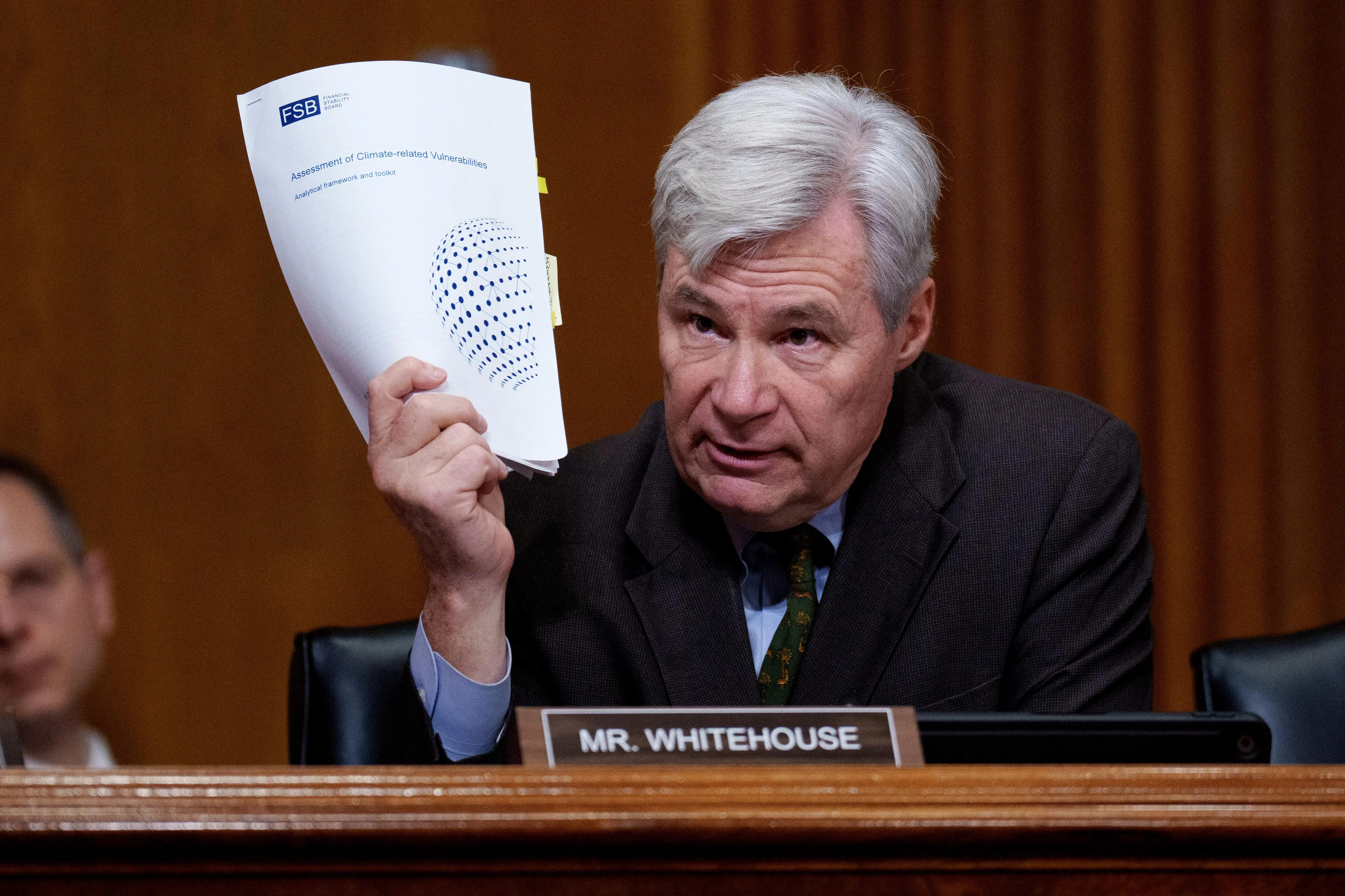 Sen. Sheldon Whitehouse holds up a document titled 