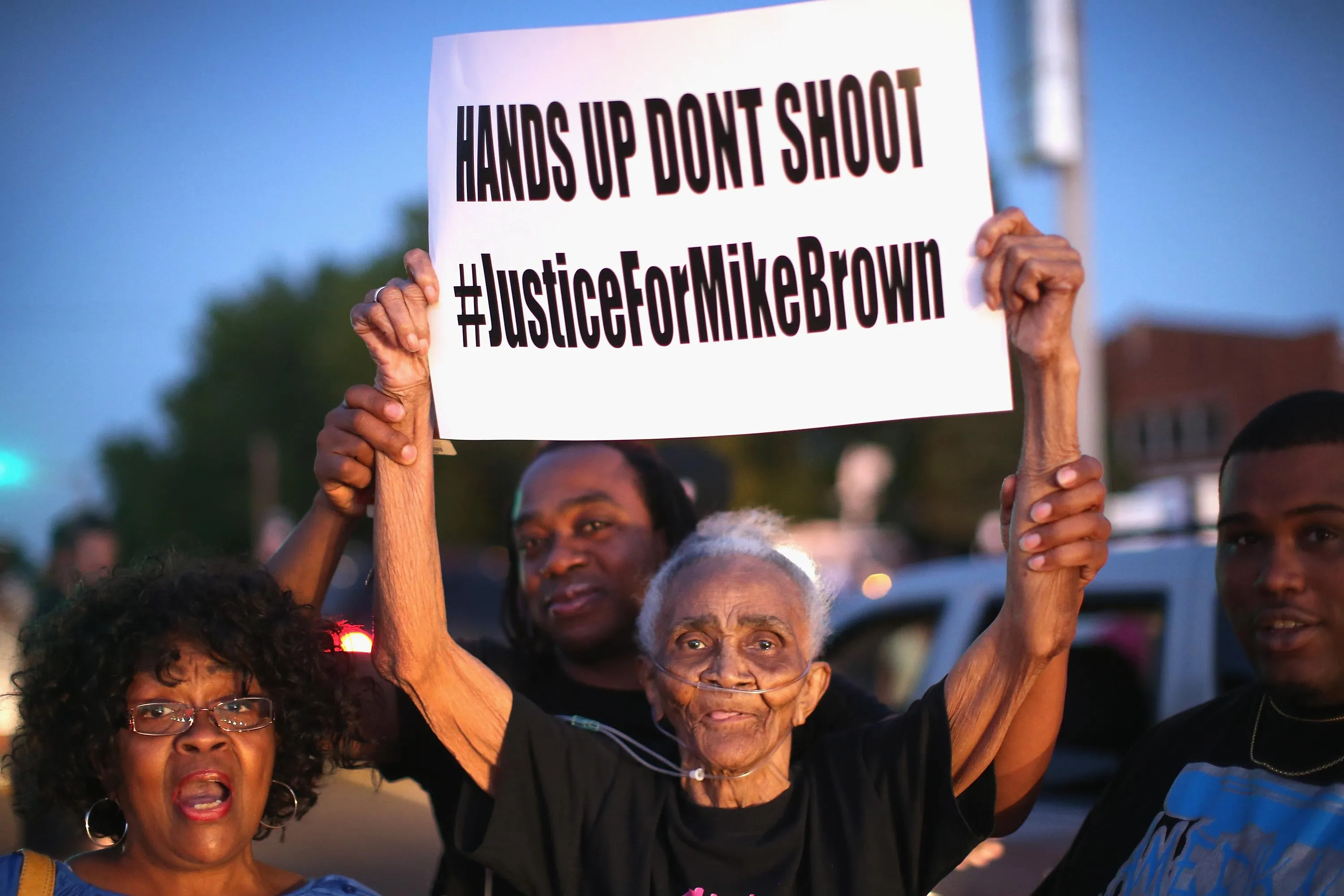 An 88yearold woman holds up a protest sign that says hands up don’t shoot An 88yearold woman holds up a protest sign that says hands up don’t shoot