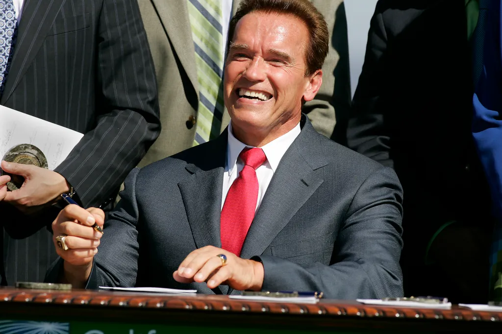 Arnold Schwarzenegger laughing at a bill signing ceremony for a law to limit greenhouse gas emissions.