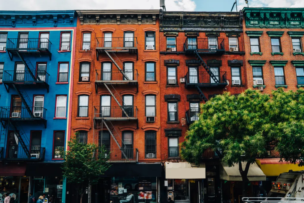 Small attached colorful buildings with fire escapes in Brooklyn.