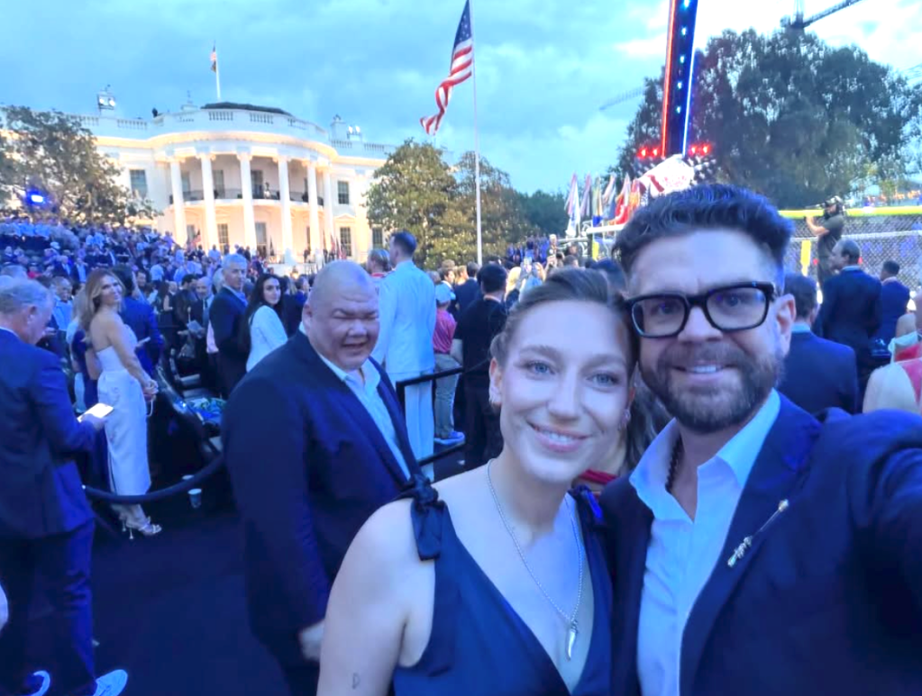 Jack Osbourne posing for a selfie with a woman at an outdoor event, with the White House in the background.