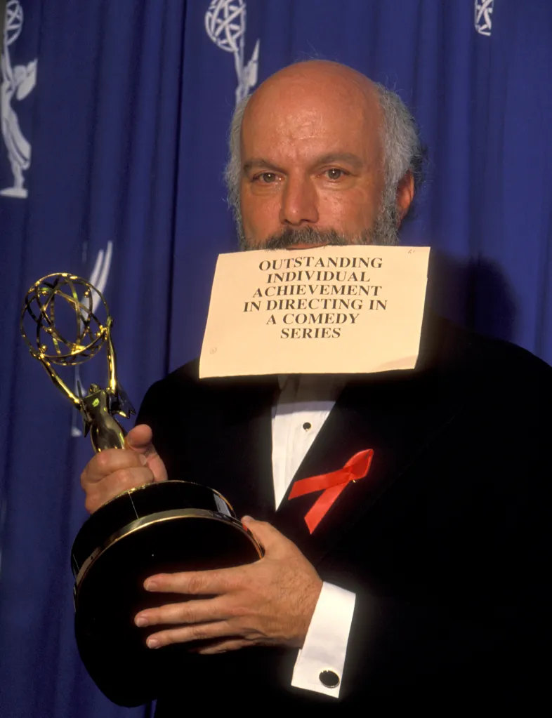 James Burrows holding an Emmy award and a sign reading "Outstanding Individual Achievement in Directing in a Comedy Series."