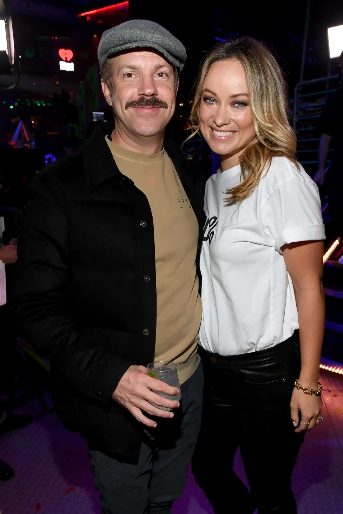 Jason Sudeikis and Olivia Wilde posing backstage at iHeartRadio's Z100 Jingle Ball 2019.