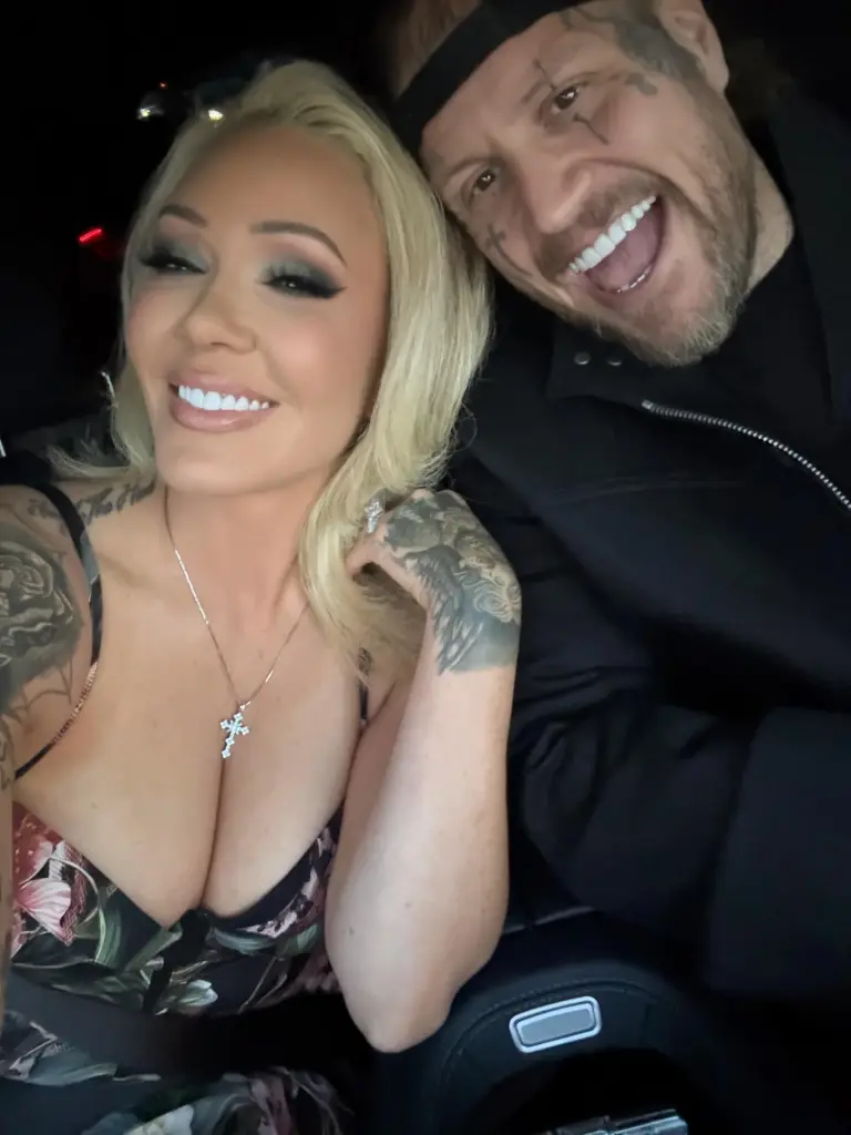 Jelly Roll and Bunnie XO smiling together in a car.