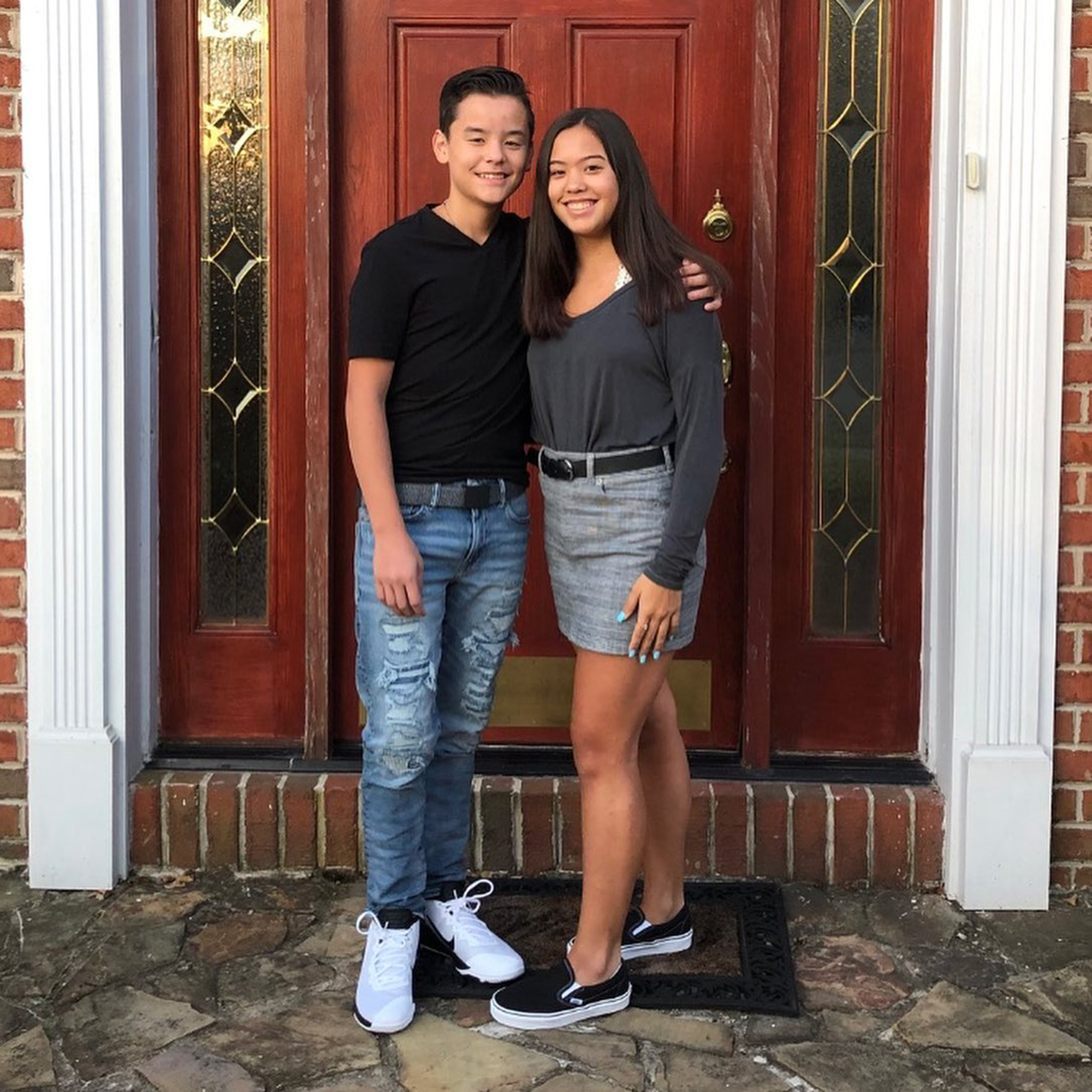 Collin and Hannah Gosselin embracing outside a red door.