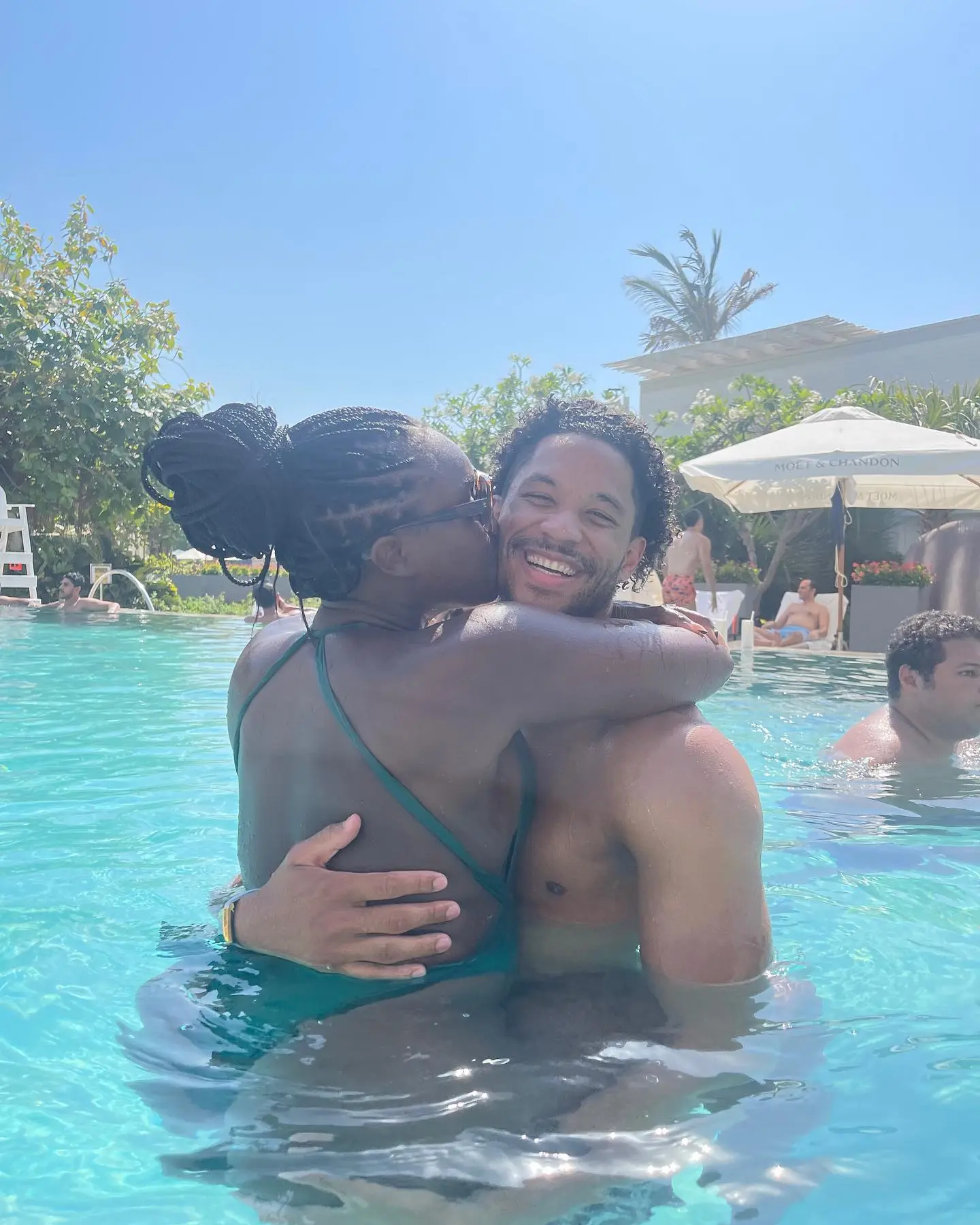 Shannon kissing Josh Hart on the cheek while in a pool.