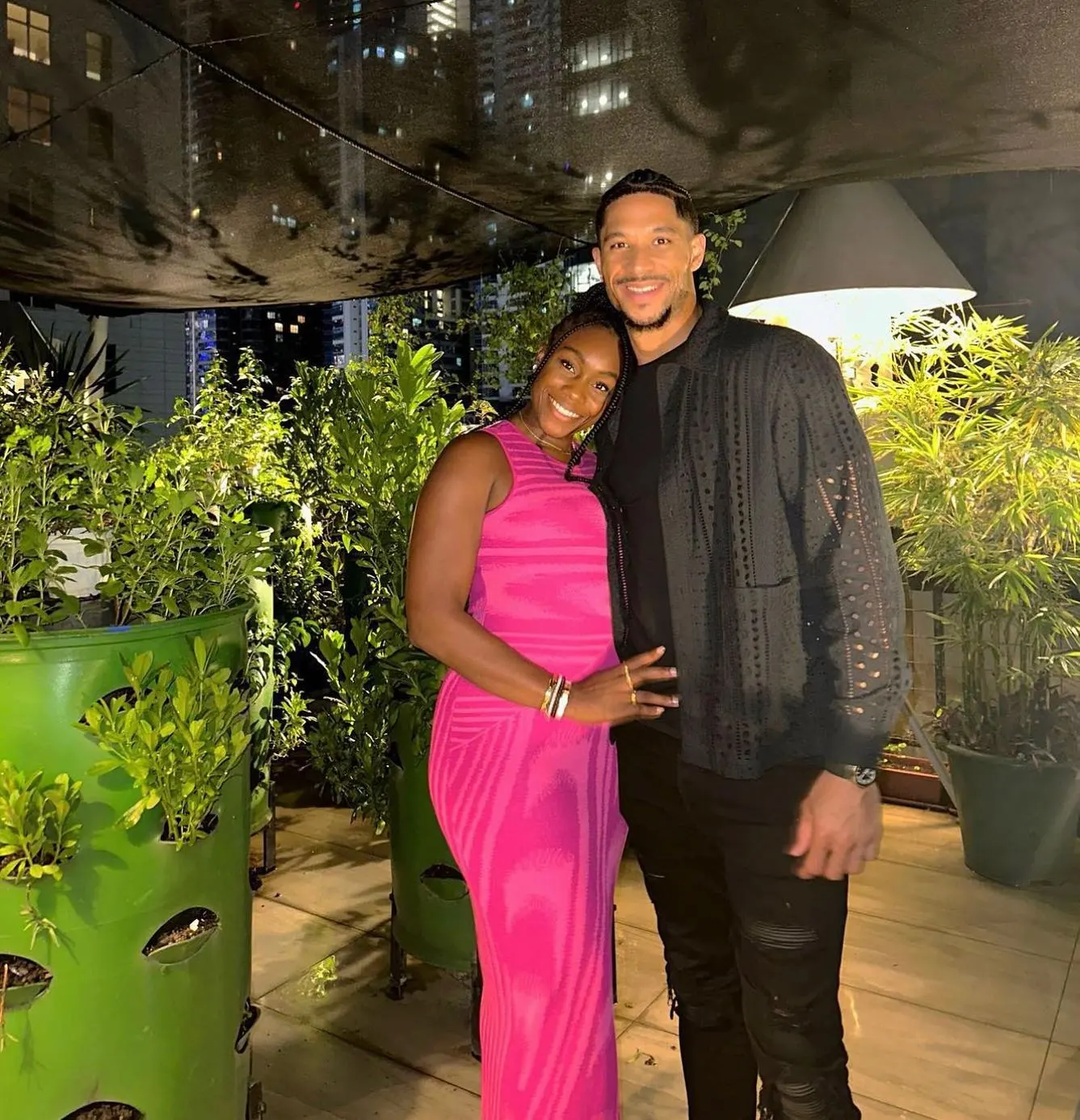 Josh Hart and Shannon smiling and posing on a rooftop.