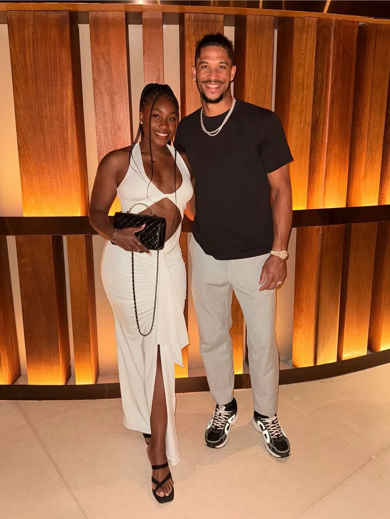 Josh Hart and Shannon standing together in front of a wooden slatted wall.
