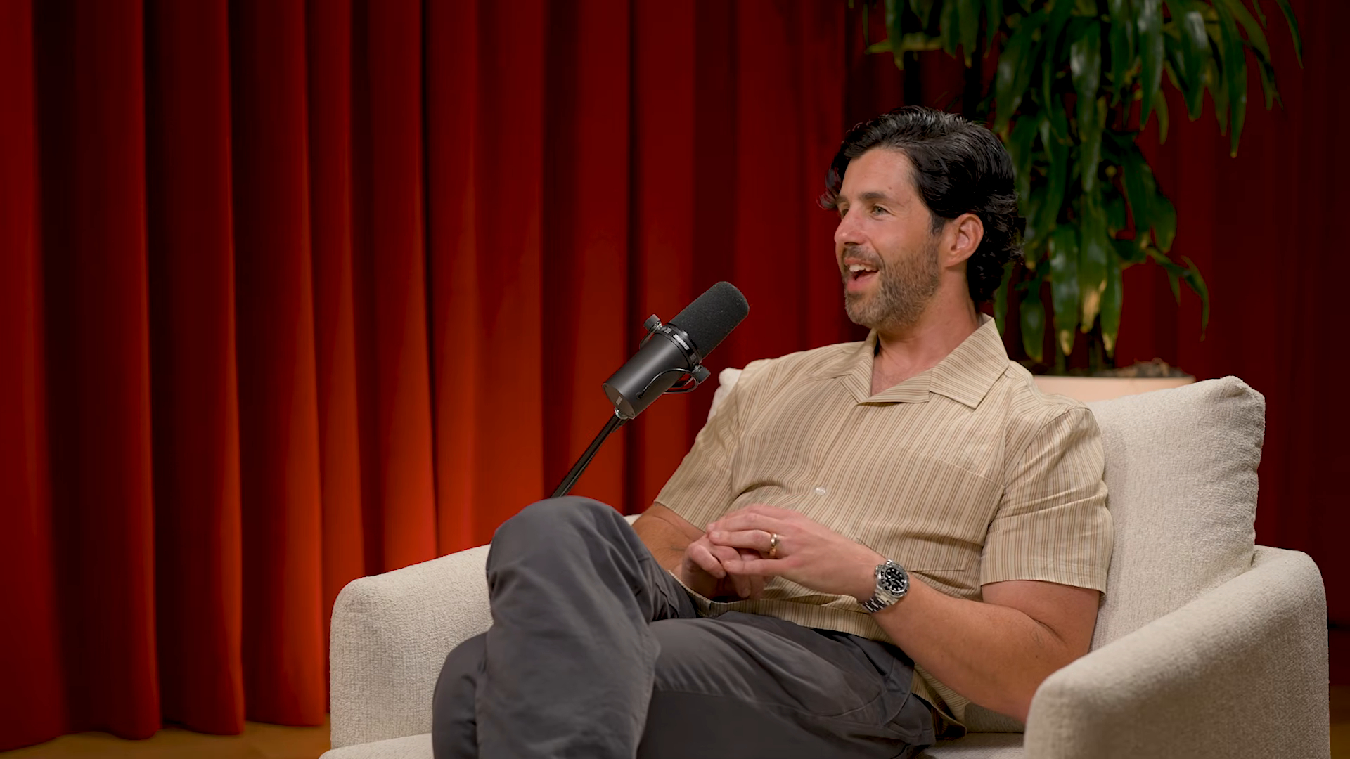 Josh Peck speaking into a microphone on the podcast "Financial Tea with Mrs. Dow Jones."