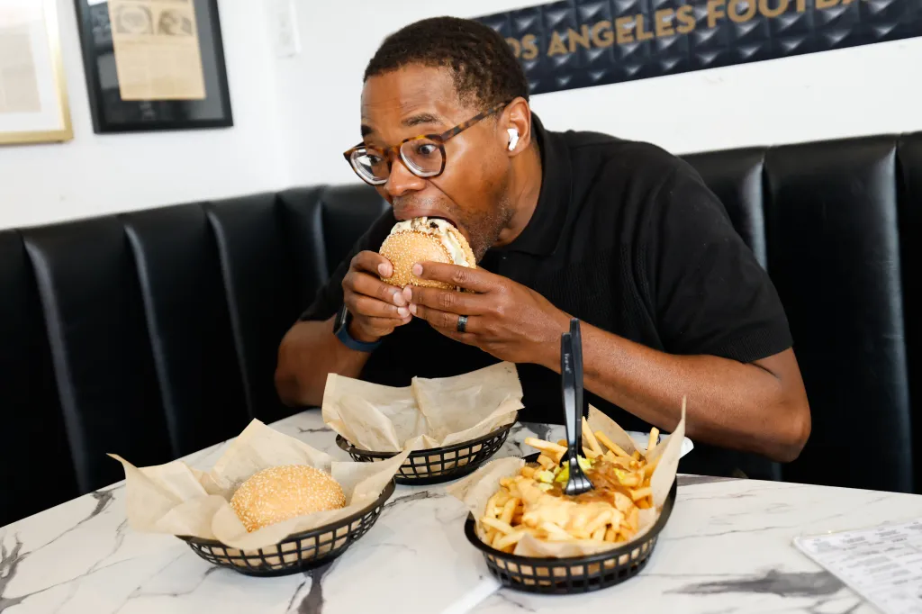 Reporter Ernest Crosby III biting into a burger at Amboy Quality Meats & Delicious Burgers.