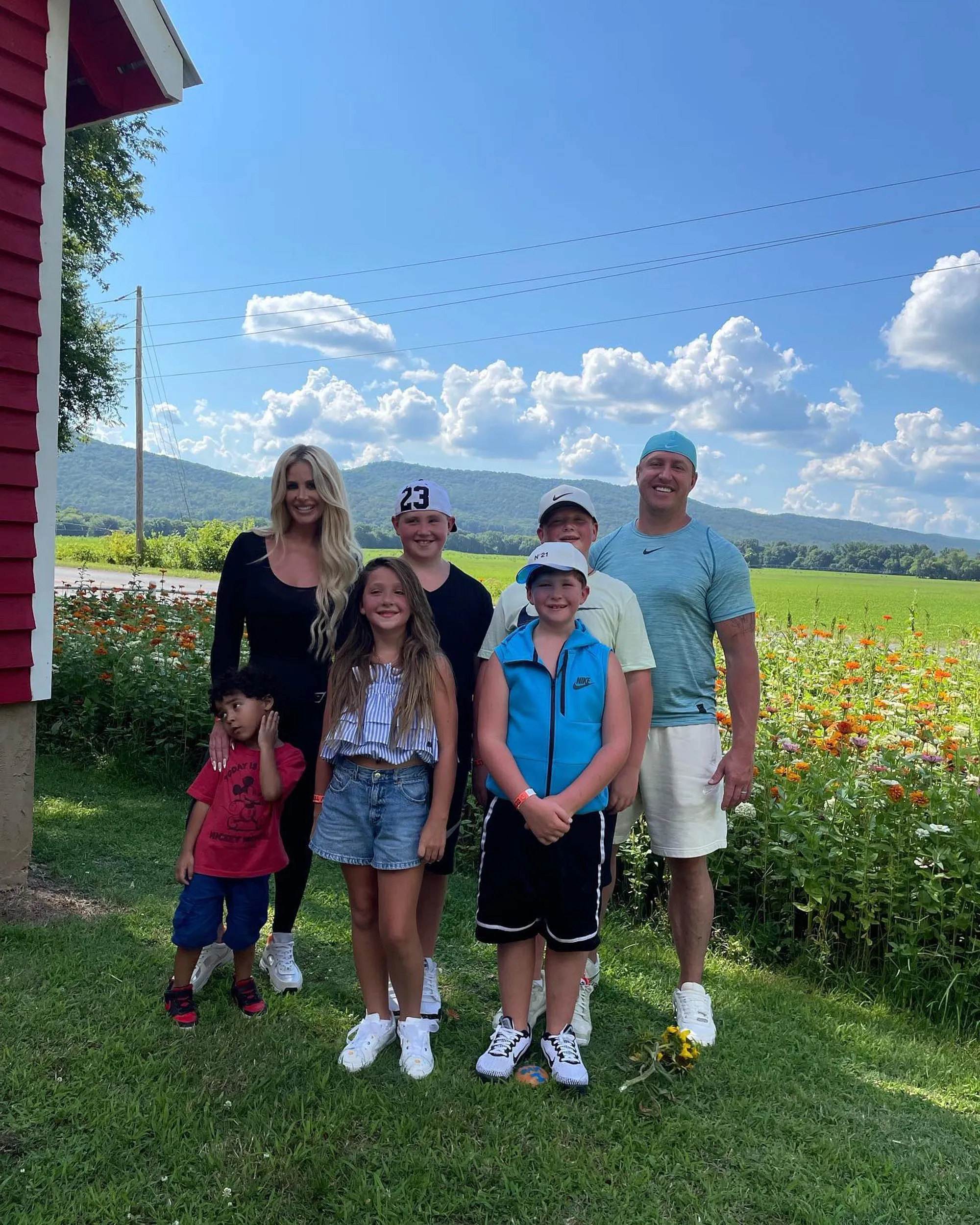 Kim Zolciak, her husband Kroy Biermann, and their children, Kroy "KJ" Jagger Jr., Kash Kade, Kaia Rose, and Kane Ren, standing together outdoors.